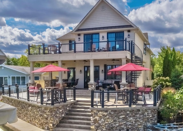 back of property with outdoor lounge area, ceiling fan, a balcony, and a patio