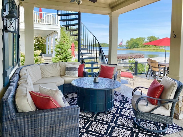 view of patio / terrace featuring an outdoor living space, a water view, ceiling fan, and a balcony