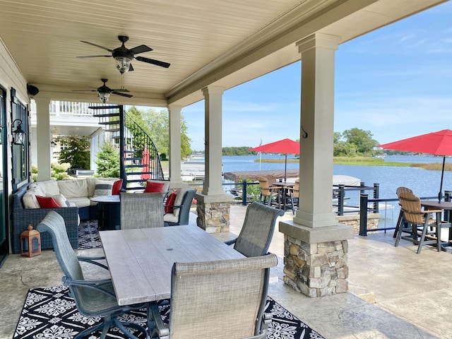 view of patio with outdoor lounge area, ceiling fan, and a water view