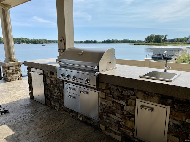 view of patio / terrace with area for grilling, a water view, sink, and grilling area