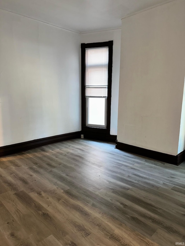 unfurnished room featuring ornamental molding and dark wood-type flooring