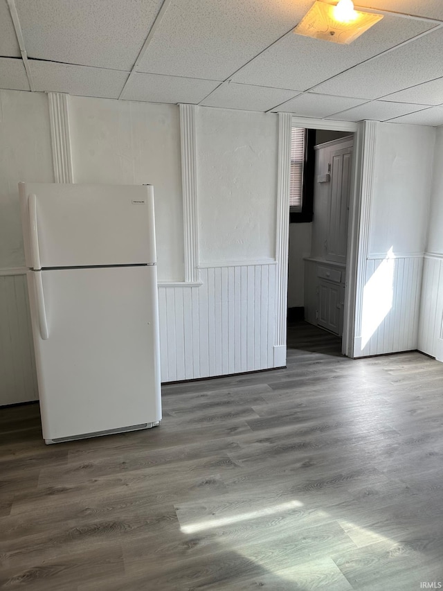 unfurnished room with a paneled ceiling and hardwood / wood-style flooring