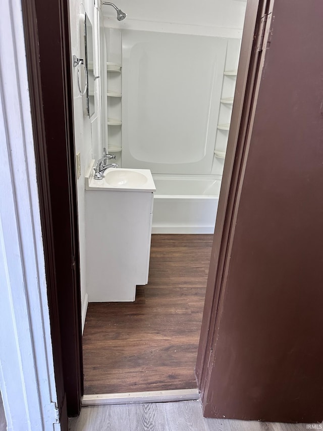 bathroom featuring hardwood / wood-style floors, vanity, and bathtub / shower combination