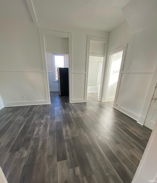 unfurnished room with dark wood-type flooring