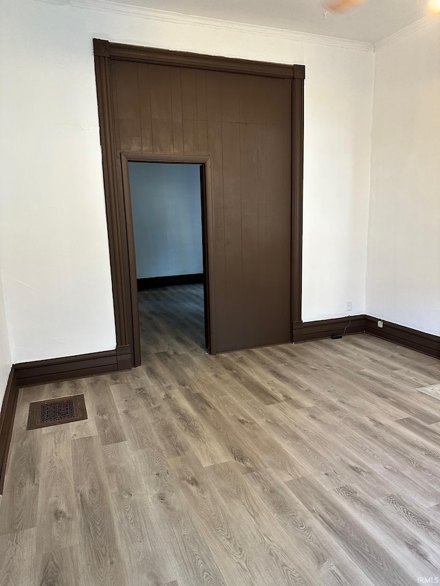 empty room featuring light hardwood / wood-style flooring and ornamental molding