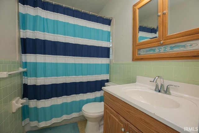 bathroom with walk in shower, toilet, vanity, and tile walls