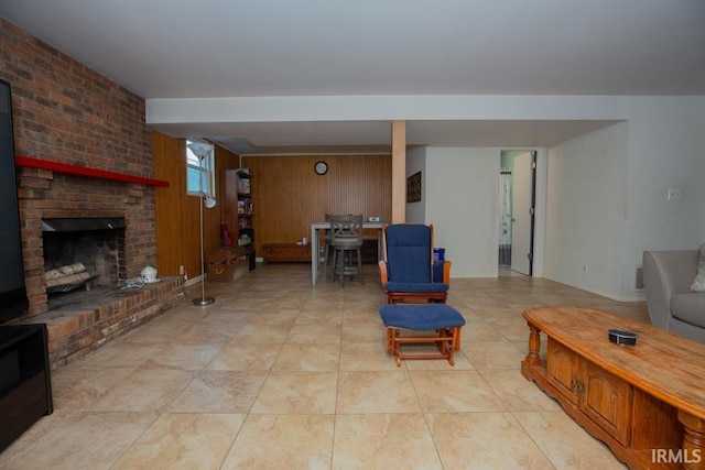 living room featuring a brick fireplace, wooden walls, and light tile patterned floors