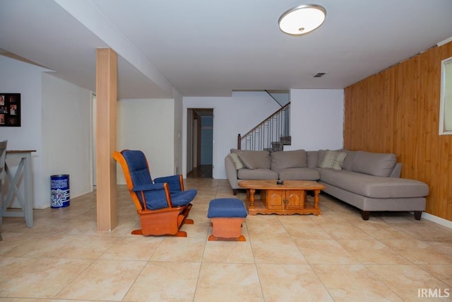 living room with wood walls and light tile patterned flooring