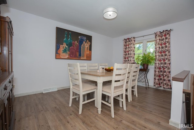 dining space with wood-type flooring