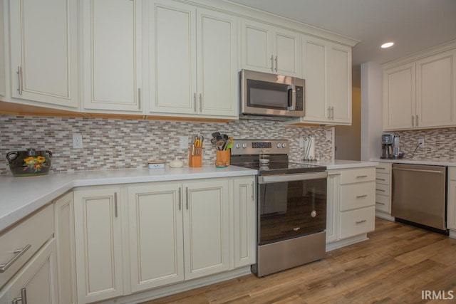 kitchen featuring stainless steel appliances, light hardwood / wood-style flooring, and tasteful backsplash