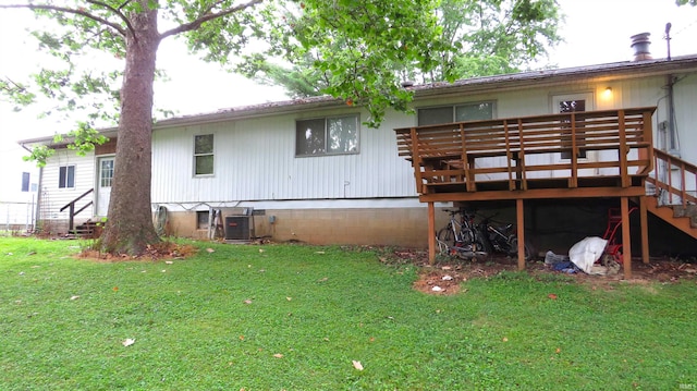 rear view of property with a deck, central air condition unit, and a yard