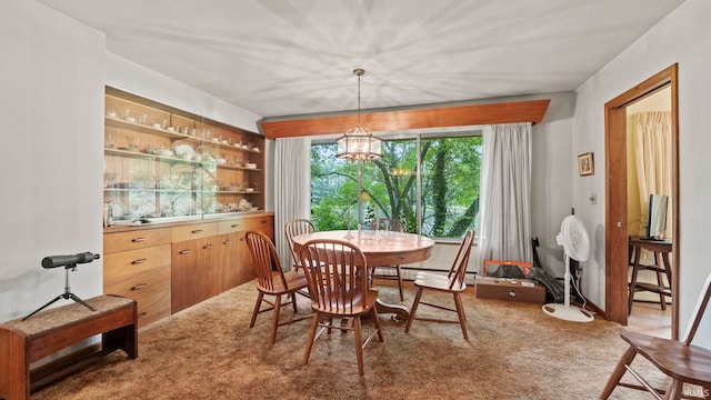 carpeted dining room with a chandelier and a baseboard heating unit