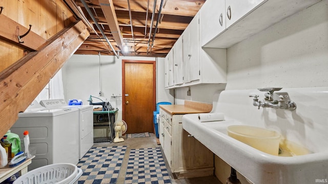 clothes washing area with cabinets, washer and clothes dryer, and sink