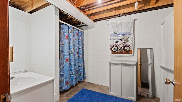 bathroom featuring concrete flooring, sink, and walk in shower