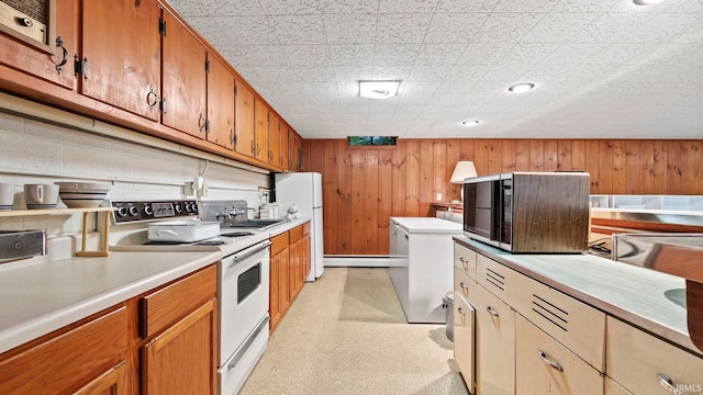 kitchen featuring wood walls, sink, and white appliances