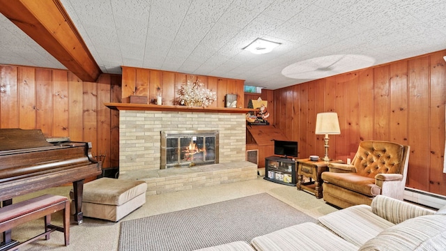 carpeted living room with beam ceiling, a fireplace, wooden walls, and a baseboard radiator