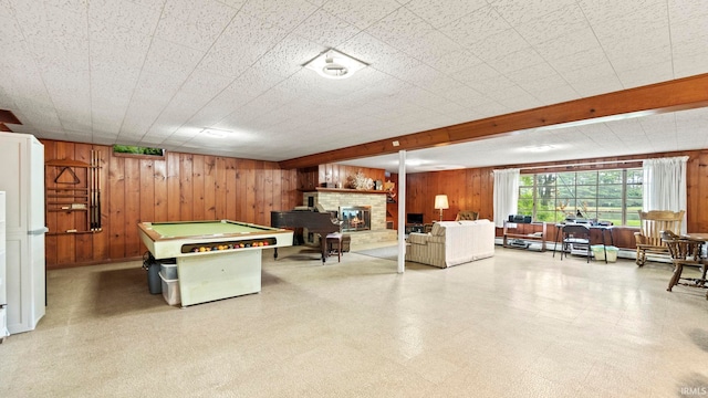 game room featuring wooden walls, a fireplace, beamed ceiling, and pool table