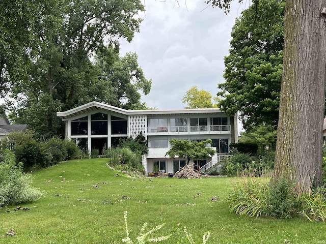 rear view of house featuring a lawn