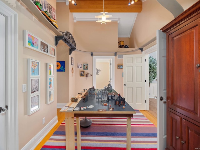 game room featuring beamed ceiling and hardwood / wood-style floors