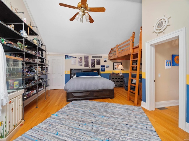 bedroom with ceiling fan, wood-type flooring, and lofted ceiling