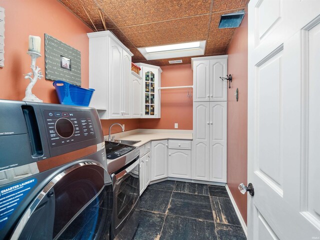 laundry area featuring cabinets, sink, and washing machine and dryer