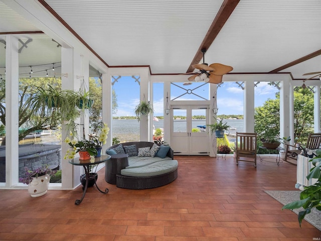 sunroom / solarium featuring beam ceiling, ceiling fan, and a water view