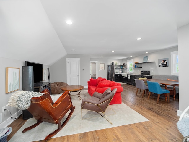 living room with light hardwood / wood-style flooring and lofted ceiling