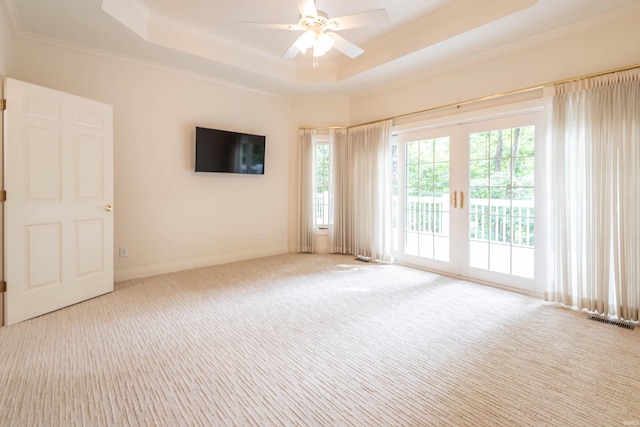 unfurnished room featuring carpet flooring, a raised ceiling, crown molding, and ceiling fan