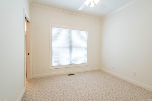 empty room with crown molding, light colored carpet, and ceiling fan