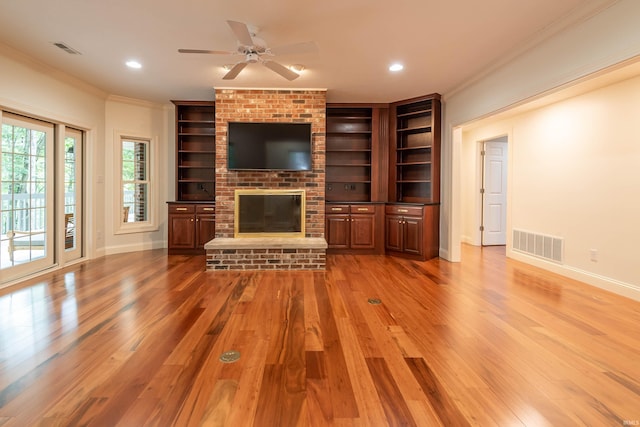 unfurnished living room with ceiling fan, a fireplace, crown molding, and wood-type flooring