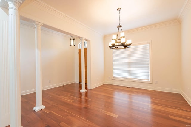 unfurnished room featuring ornate columns, wood-type flooring, crown molding, and a chandelier