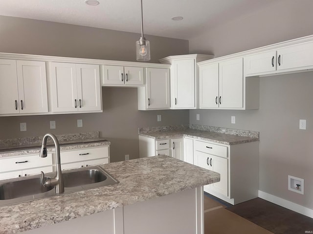 kitchen with hanging light fixtures, sink, and white cabinets