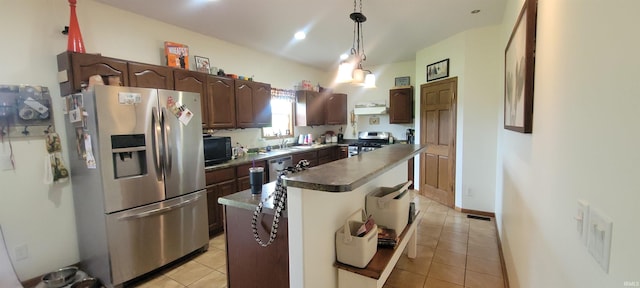 kitchen with dark brown cabinets, light tile patterned floors, appliances with stainless steel finishes, a kitchen island, and pendant lighting