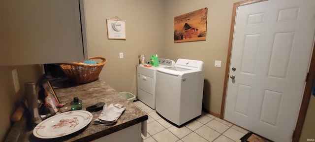 clothes washing area featuring washer and clothes dryer and light tile patterned floors