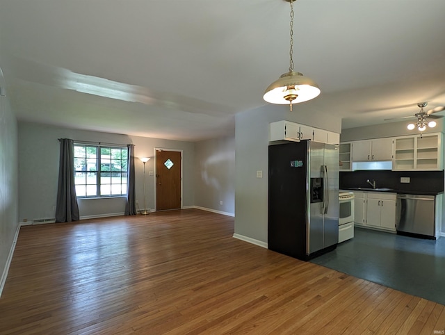 kitchen with sink, stainless steel appliances, dark hardwood / wood-style floors, white cabinets, and decorative light fixtures