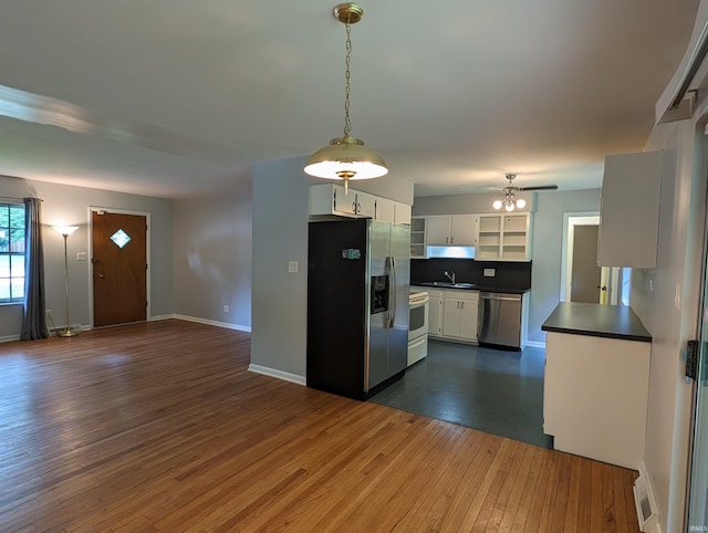 kitchen featuring sink, white cabinetry, decorative light fixtures, appliances with stainless steel finishes, and dark hardwood / wood-style floors