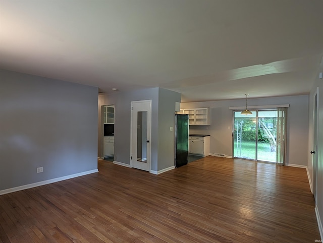 unfurnished living room with dark wood-type flooring