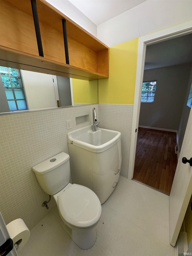 bathroom featuring tile walls, plenty of natural light, and toilet