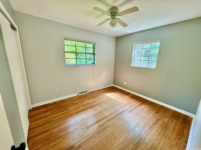 unfurnished bedroom featuring multiple windows, light hardwood / wood-style floors, and a closet