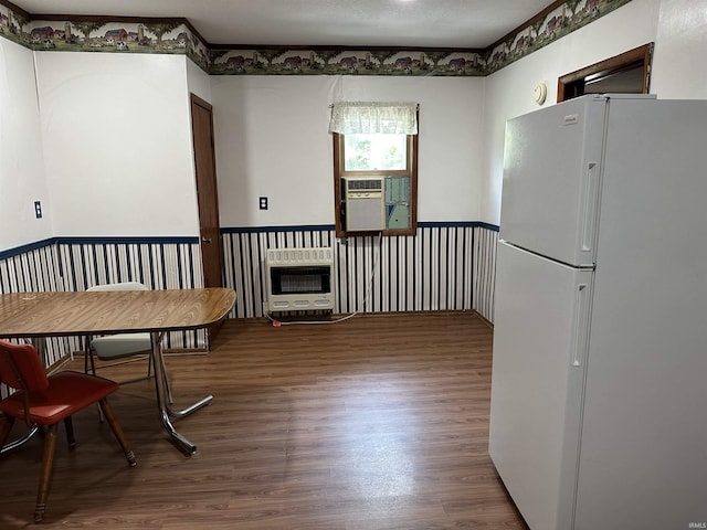 dining area featuring wood-type flooring and heating unit