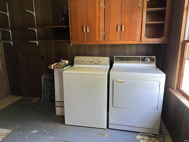 laundry room featuring cabinets, washing machine and dryer, and wooden walls