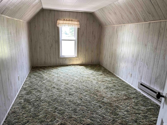 additional living space with carpet flooring, wood walls, and lofted ceiling