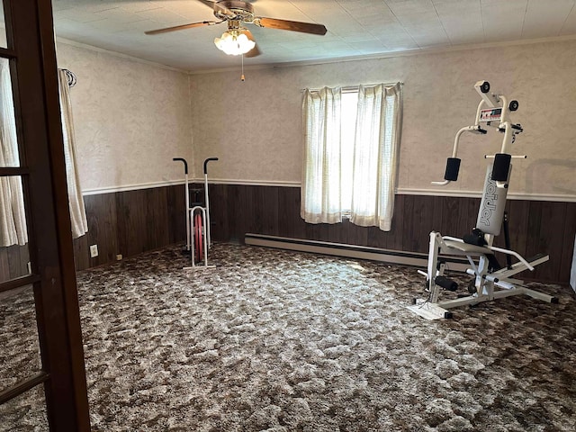 interior space with carpet flooring, ceiling fan, ornamental molding, and wooden walls