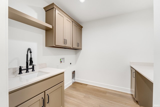 laundry room with sink, cabinets, hookup for a washing machine, hookup for an electric dryer, and light wood-type flooring