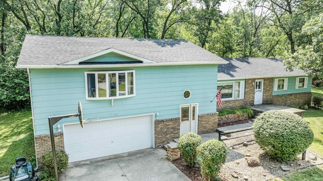 view of front facade featuring brick siding, an attached garage, a shingled roof, and driveway