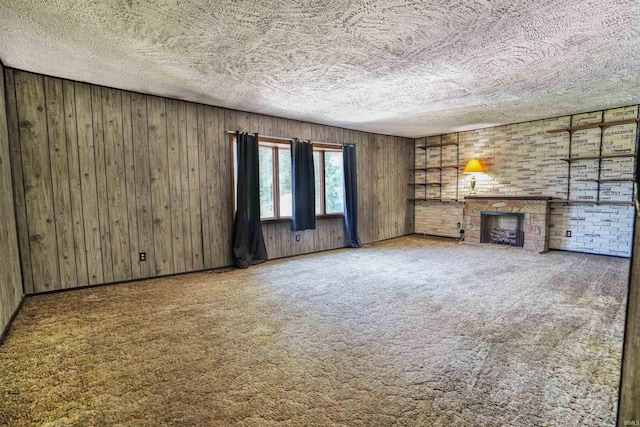 unfurnished living room with wood walls, carpet, and a fireplace