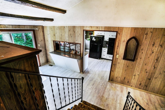 stairs featuring wooden walls, visible vents, lofted ceiling with beams, wood finished floors, and a textured ceiling