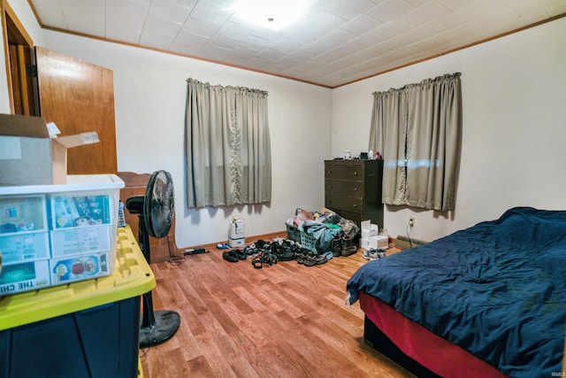 bedroom featuring ornamental molding and hardwood / wood-style floors