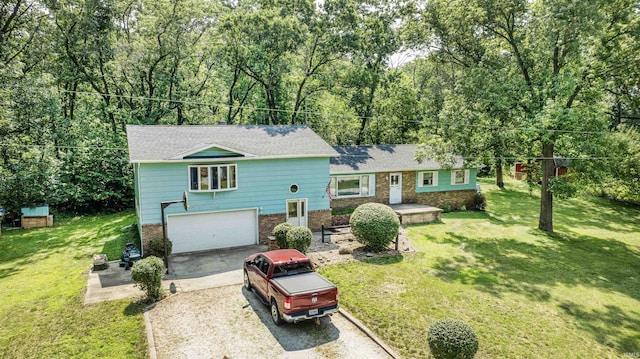 tri-level home featuring brick siding, a shingled roof, a front yard, driveway, and an attached garage