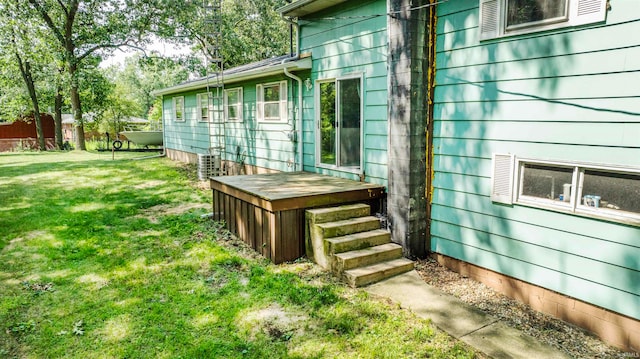 exterior space featuring a yard, a deck, and cooling unit